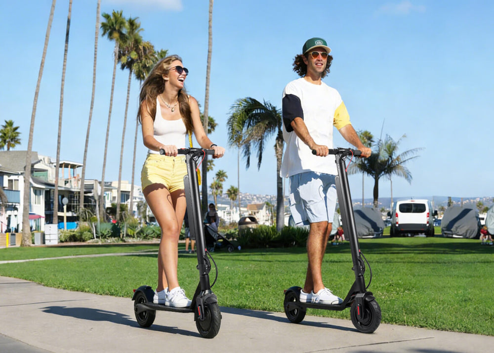 Two people riding electric scooters on a sidewalk with palm trees and buildings in the background.